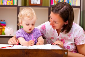 Мама учит маленькую девочку писать