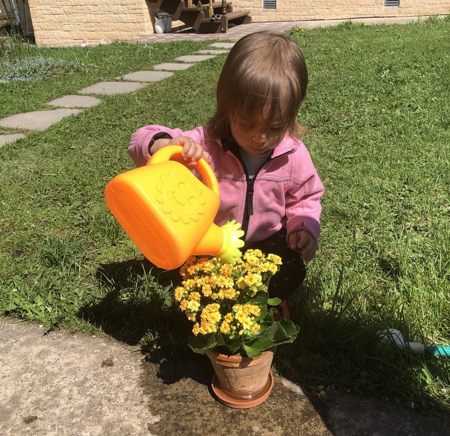 Ребёнок поливает цветы